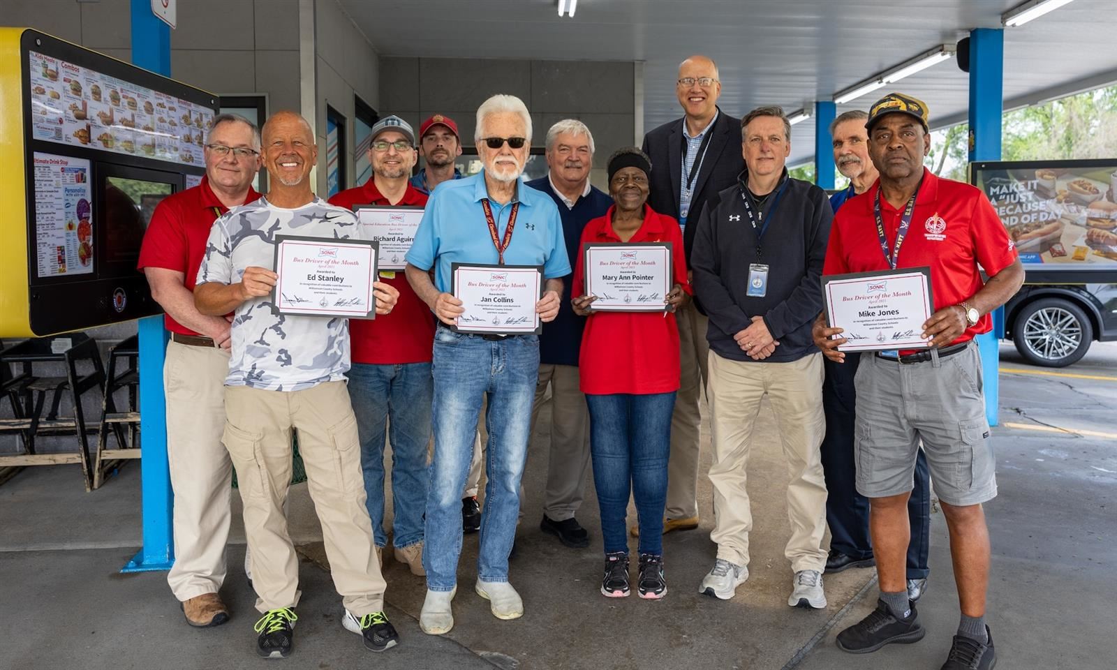 Bus drivers hold up certificates